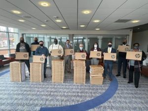Image of group standing behind boxes of laptop computers