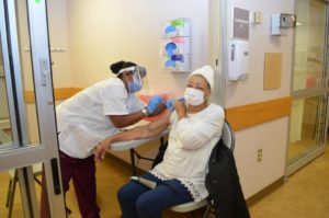 Image of one woman vaccinating another