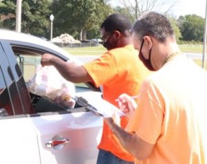 Image of two men distributing bags of food