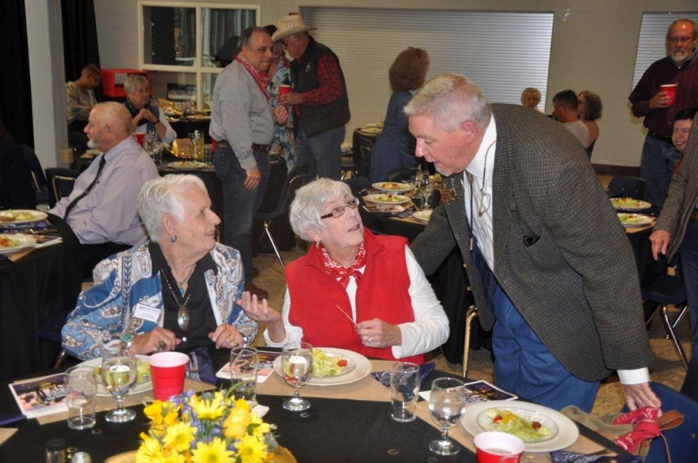 A trio of donors gather around a table