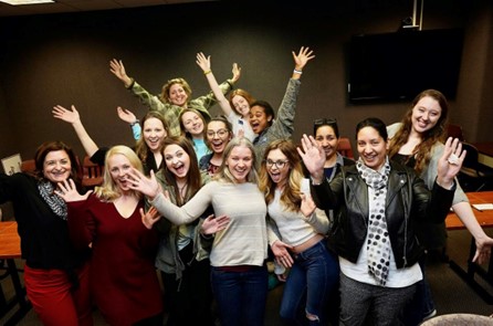Group of students with arms raised high