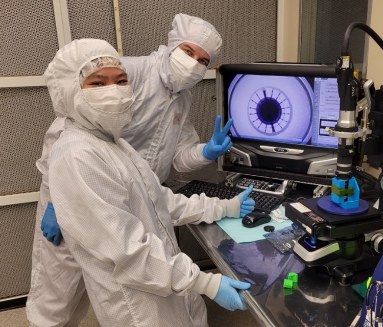 Two students wearing lab clothing