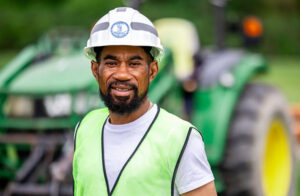 Man in hardhat in front of heavy equipment