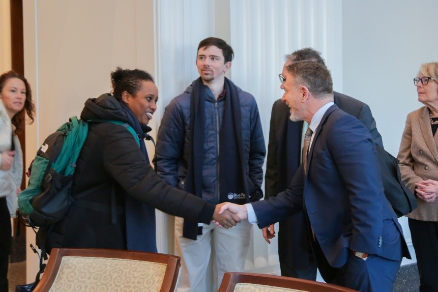 Image of Chancellor Dore shaking hands with student