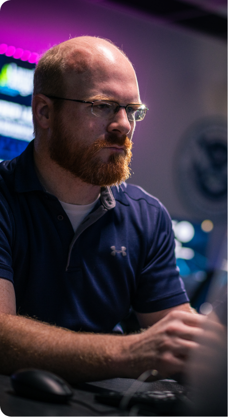 A man seated at a desk using a computer.