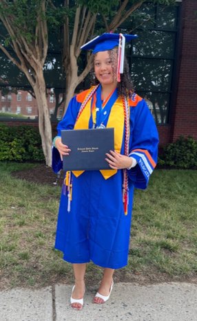 Samantha Pennington in her graduation cap and gown, holding her diploma