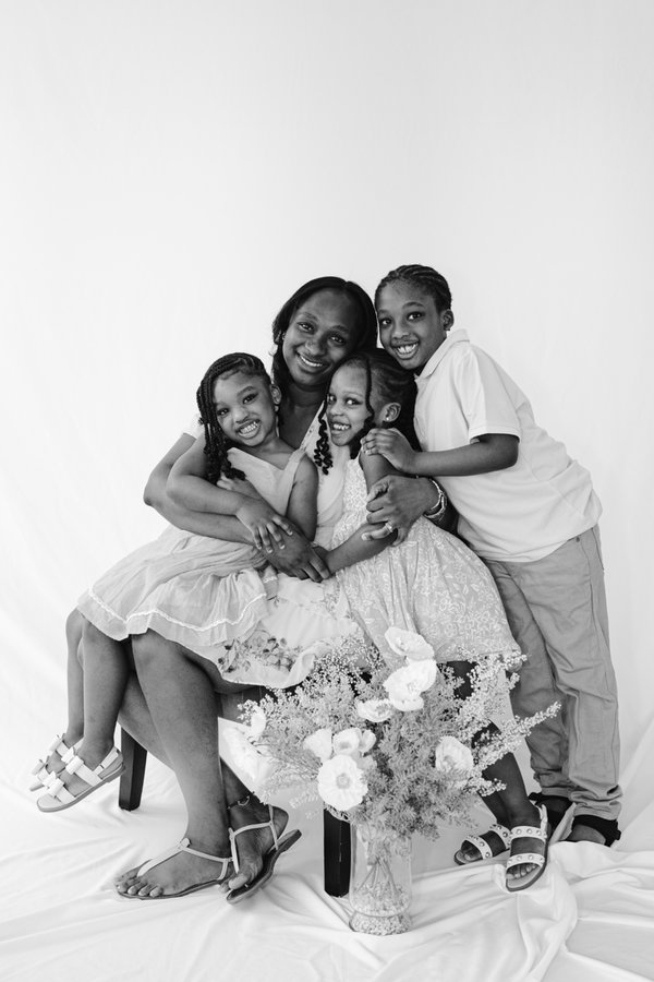 Susana Donkor in a black and white portrait with her three children