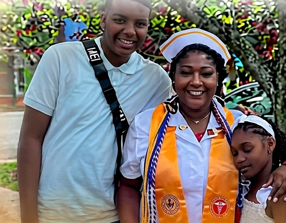 A mother in graduation regalia with her two children